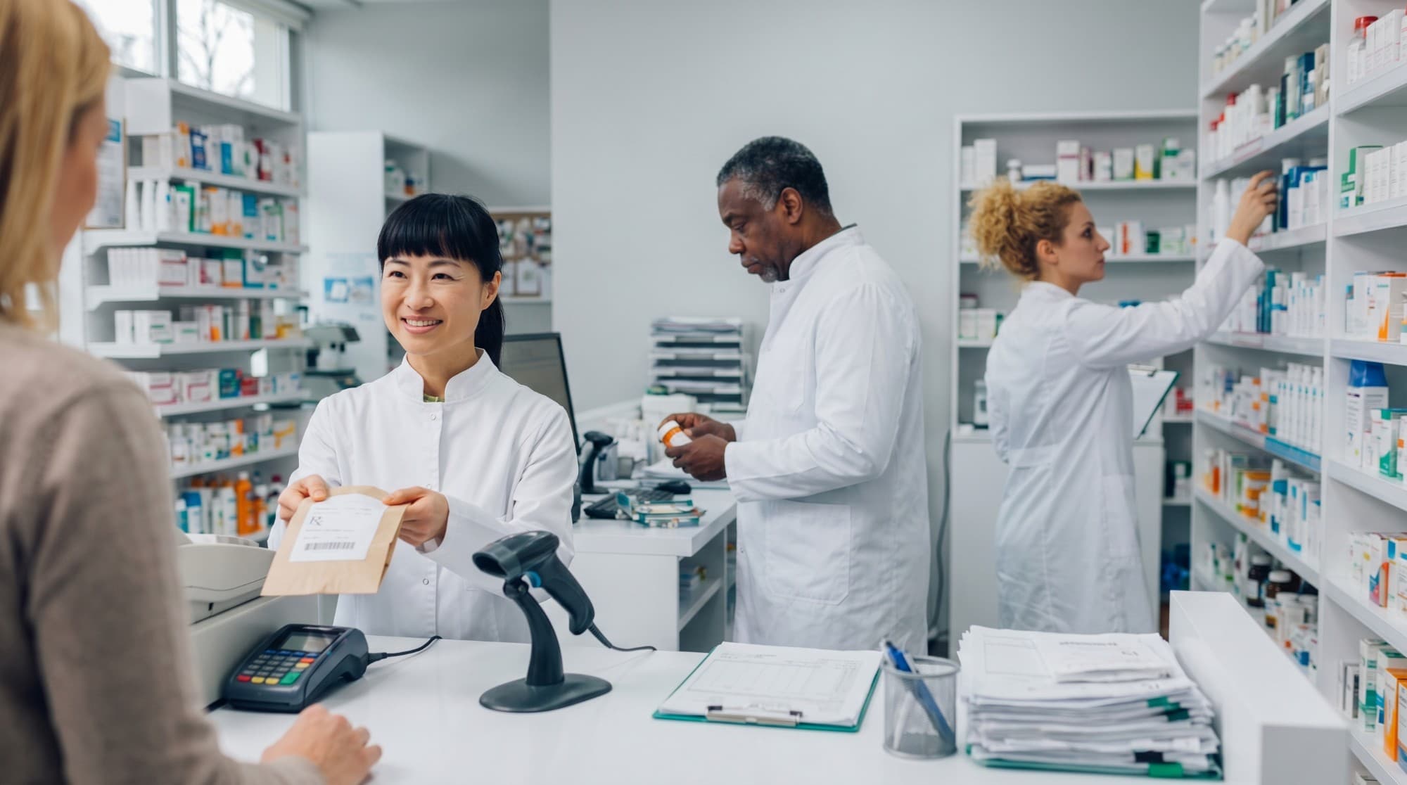 Une assistante technique remet une ordonnance à une cliente au comptoir